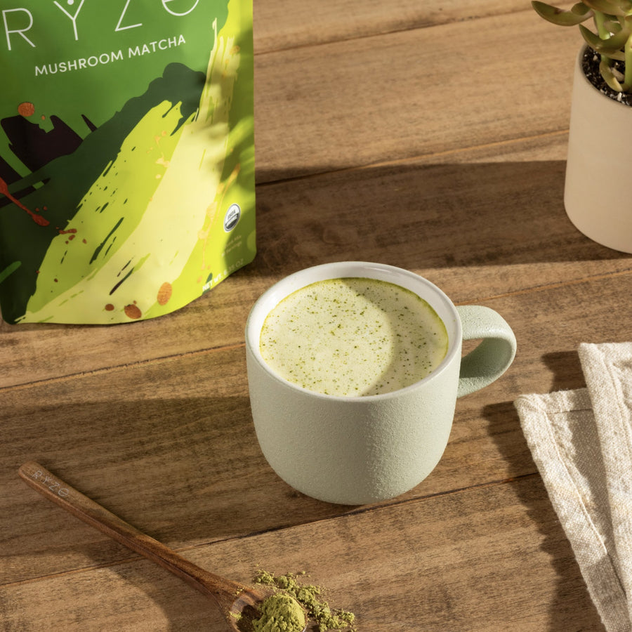 Taza de matcha de hongos RYZE servida en mesa de madera